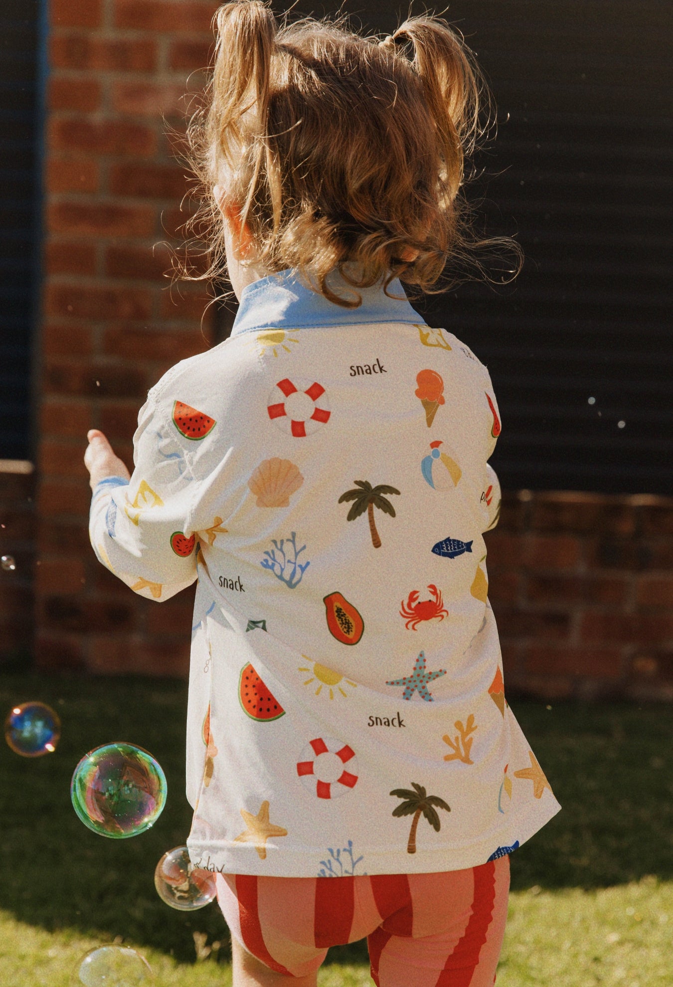 Child wearing Golden Days kids UPF 50+ sunwear shirt outdoors